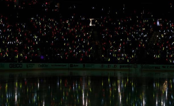 Fans wave light sticks before the Seattle Kraken's inaugural regular-season game against the Vegas Golden Knights at T-Mobile Arena on October 12,...