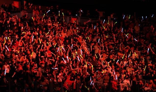 Fans wave light sticks before the Seattle Kraken's inaugural regular-season game against the Vegas Golden Knights at T-Mobile Arena on October 12,...