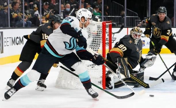 Robin Lehner of the Vegas Golden Knights defends the net against Alex Wennberg of the Seattle Kraken in the first period of the Kraken's inaugural...