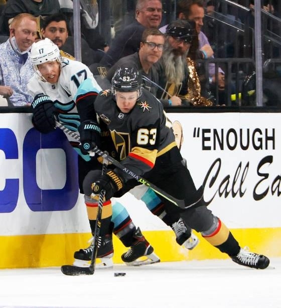 Evgenii Dadonov of the Vegas Golden Knights tries to control the puck against Jaden Schwartz of the Seattle Kraken in the first period of the...
