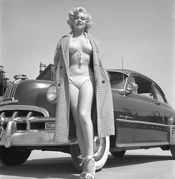 Rising star Marilyn Monroe poses for a portrait next to a 1950 Pontiac Chieftain on the backlot of 20th Century-Fox in 1951 in Los Angeles,...