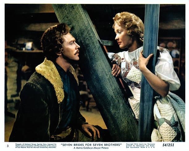 Howard Keel talks to Jane Powell as she sits on a staircase in a scene from the film 'Seven Brides For Seven Brothers', 1954.