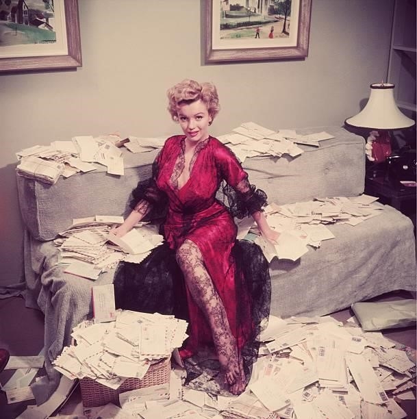 Premium Rates Apply. Marilyn Monroe , wearing a red negligee trimmed with black lace, sorts out her fan mail shortly after her film 'The Asphalt...