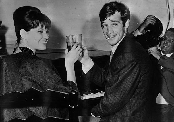 French film actor Jean-Paul Belmondo with Italian actress Claudia Cardinale making a toast at a press reception in Rome.