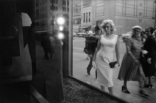 Marilyn Monroe in 1957 in front of store window on Fifth Avenue in New York, New York.