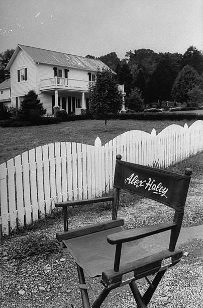 Late author Alex Haley's empty director chair emblazoned w. His name, sitting on road next to white fence in front of his 2-story farmhouse which is...