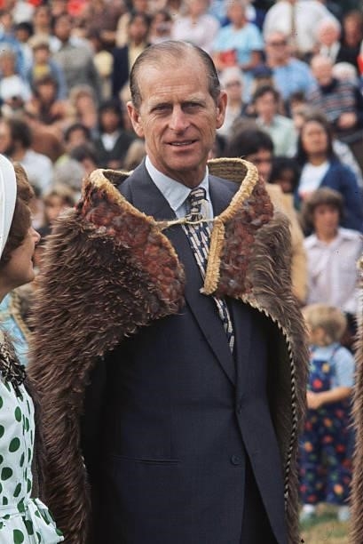 Prince Philip, Duke of Edinburgh wears a kiwi feather cloak on a visit to Gisborne, New Zealand, during the Silver Jubilee Commonwealth Tours,...