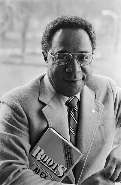 Writer Alex Haley holds a copy of his book Roots during a visit to London.