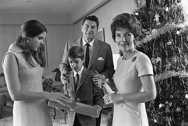 California Governor Ronald Reagan and his wife, Nancy , gather around the Christmas tree with children Patti, and Ron, Jr., December 1970.