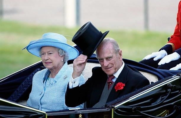 Queen Elizabeth II with Prince Philip wearing traditional top hat and tails in the carriage procession on the second day at Royal Ascot races. He Is...