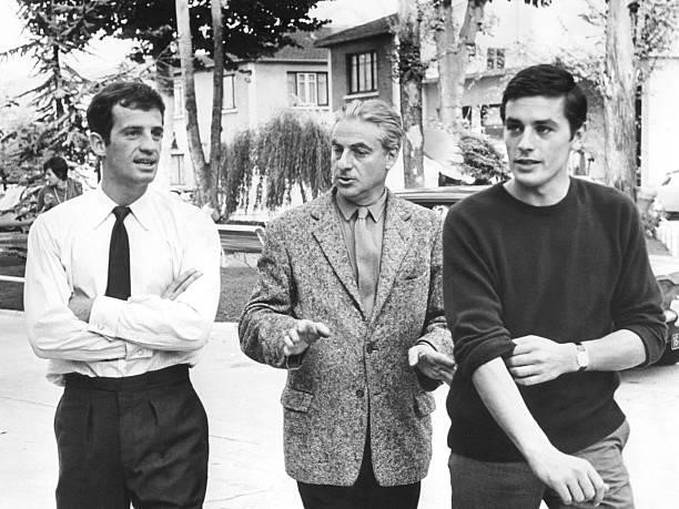 French actors Jean-Paul Belmondo and Alain Delon with director Rene Clement on the set of Clement's movie Paris brule-t-il? .