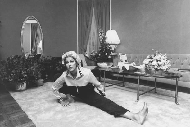 Television actress Lynda Carter stretching in a living room in 1979.
