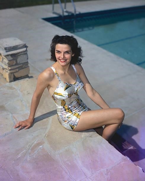 American actress Jane Russell sits by the side of a swimming pool, circa 1950.