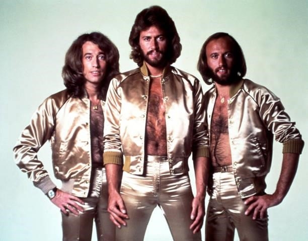 Disco group the Bee Gees pose for a portrait in gold lame outfits in 1977.