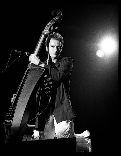 Photo of POLICE and STING, Sting performing live onstage, playing Van Zalinge Z Bass, upright bass