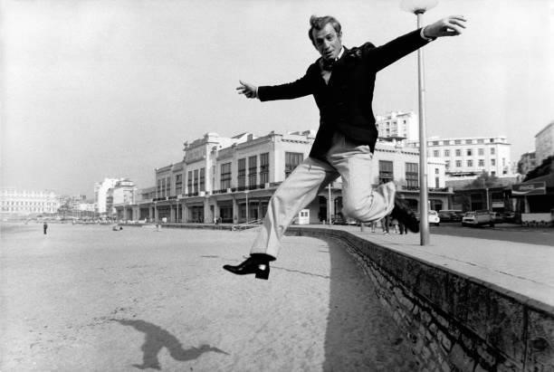 Jean-Paul Belmondo se promène devant le casino de Biarritz entre deux prises du film 'Stavisky' dirigé par Alain resnais, le 12 octobre 1973, France.