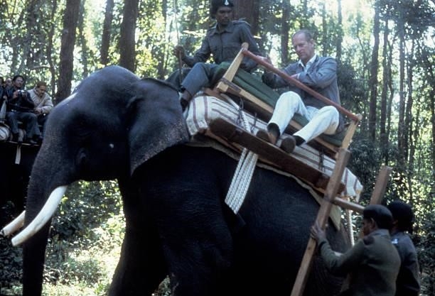Prince Philip, Duke of Edinburgh rides an elephant during a visit to the Kanha Game Reserve, India, November 21, 1983.